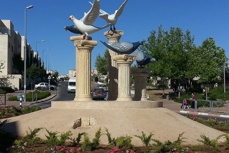 כיכר בעיר ביתר עילית עם פסלי יונים ועמודים