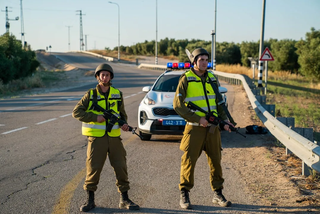 חיילי המשטרה הצבאית עומדים במחסום לצד ניידת