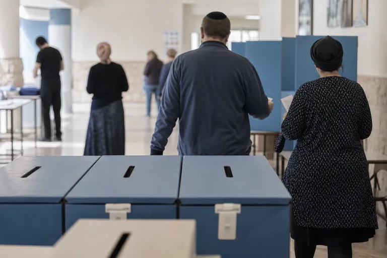 קלפיות במסדרון של מתחם הצבעה, כשבוחרים נראים מאחור באופן לא מזוהה.